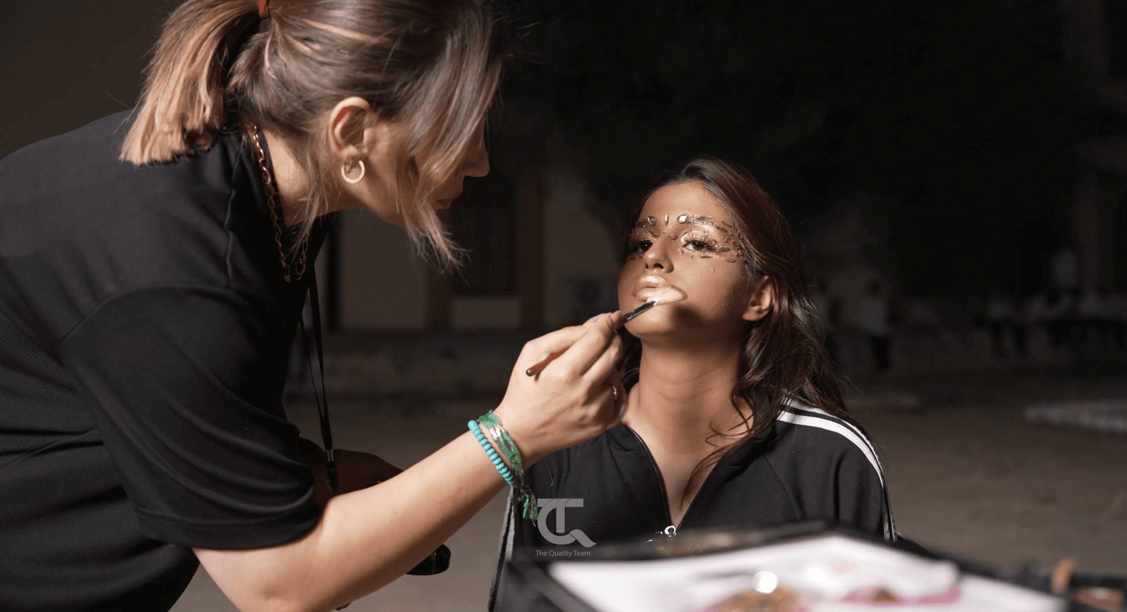 A makeup artist adorns a little girl